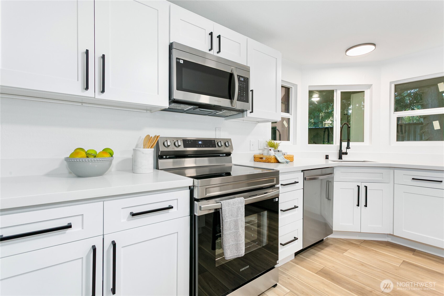 8021 Northeast Eglon Road Kingston, WA 98346 - Photo 9 of 35 a kitchen with stainless steel appliances white cabinets a sink and a stove