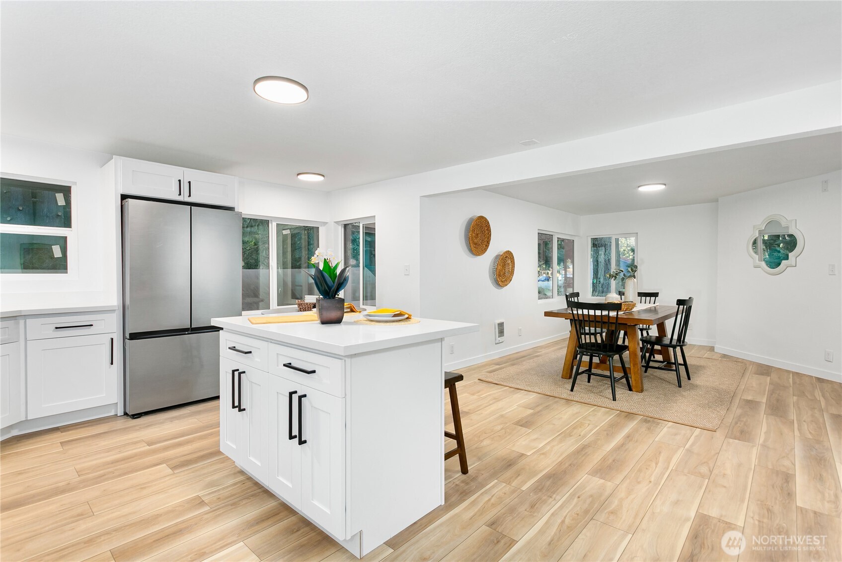 8021 Northeast Eglon Road Kingston, WA 98346 - Photo 10 of 35 a kitchen with stainless steel appliances kitchen island granite countertop a table chairs and a refrigerator