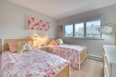 a bedroom with two beds and a large window