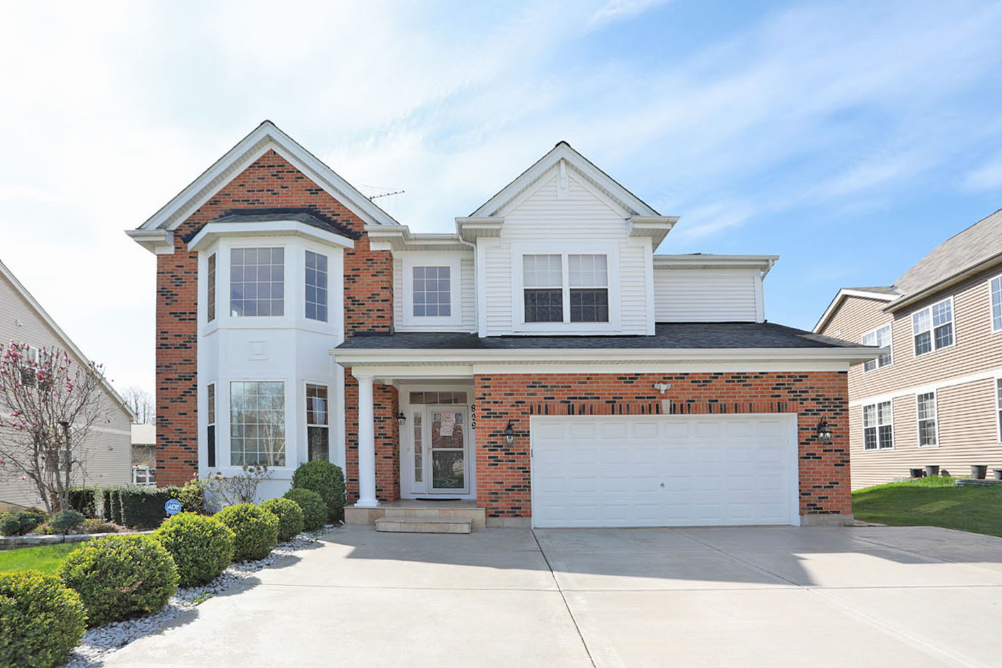 a front view of a house with yard and parking