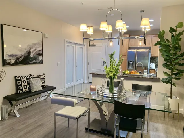 a dining room with furniture a chandelier and wooden floor