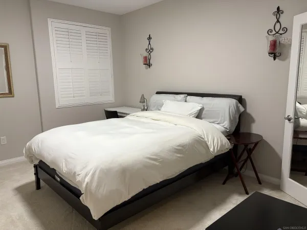 a large bed sitting in a bedroom next to a window