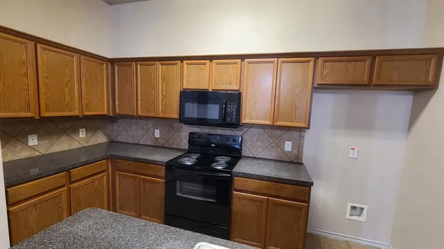 a kitchen with stainless steel appliances granite countertop a refrigerator and a stove top oven