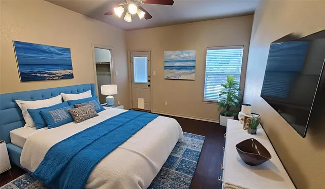 a bedroom with bed mirror and window