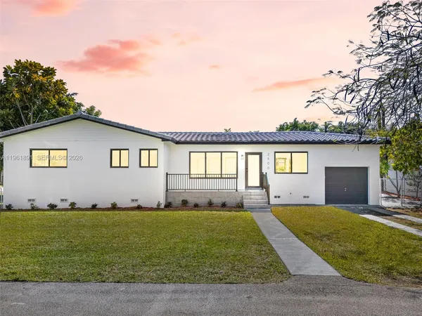 a front view of a house with a garden and yard