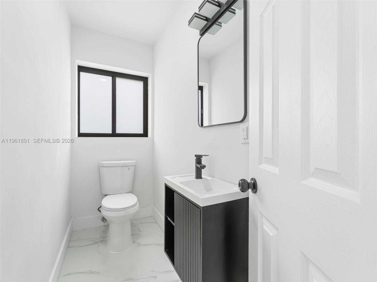 2500 Southwest 23rd Terrace Miami, FL 33145 - Photo 17 of 36 a bathroom with a toilet sink and mirror