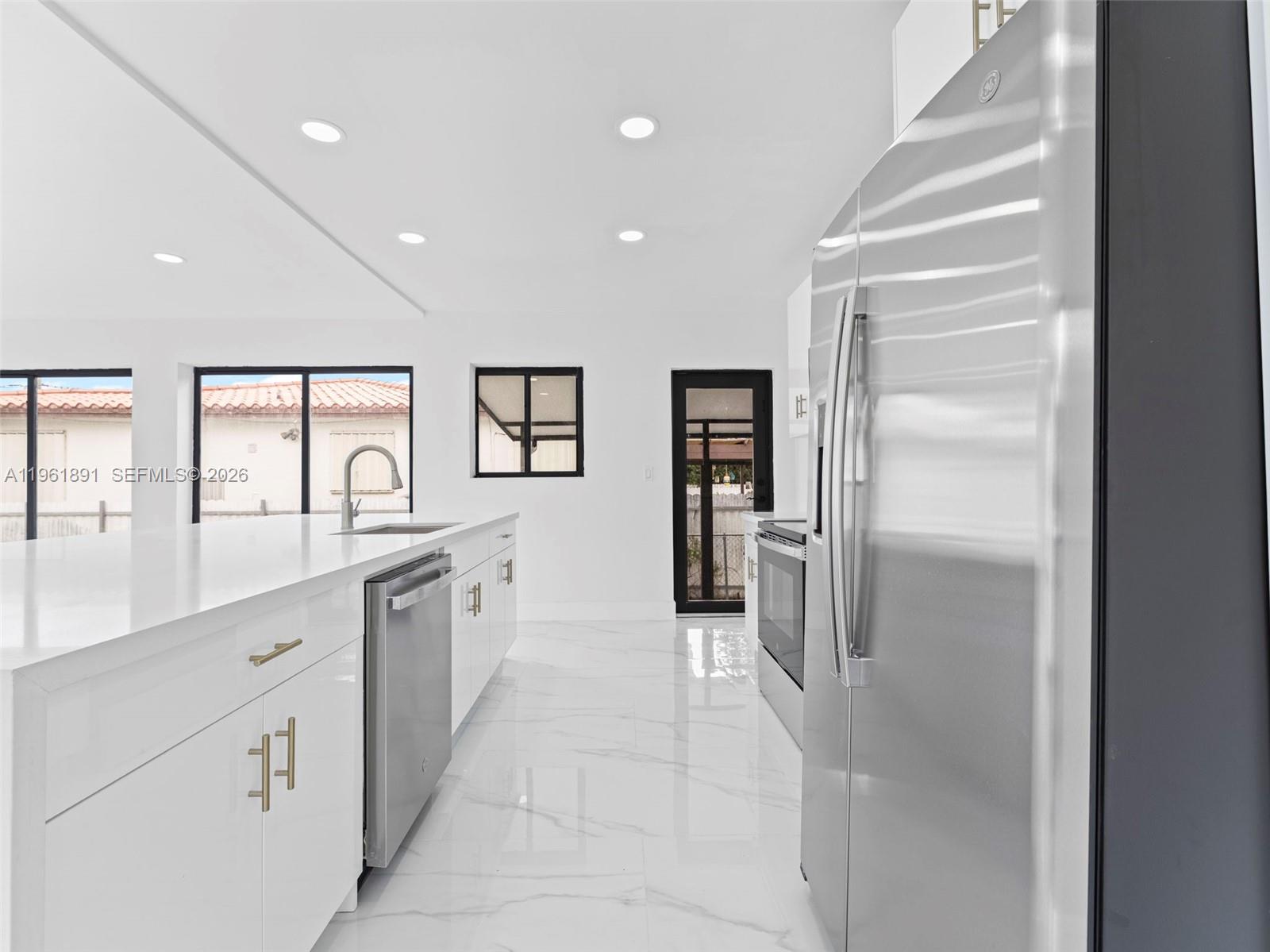 2500 Southwest 23rd Terrace Miami, FL 33145 - Photo 6 of 36 a large white kitchen with a refrigerator a sink and dishwasher