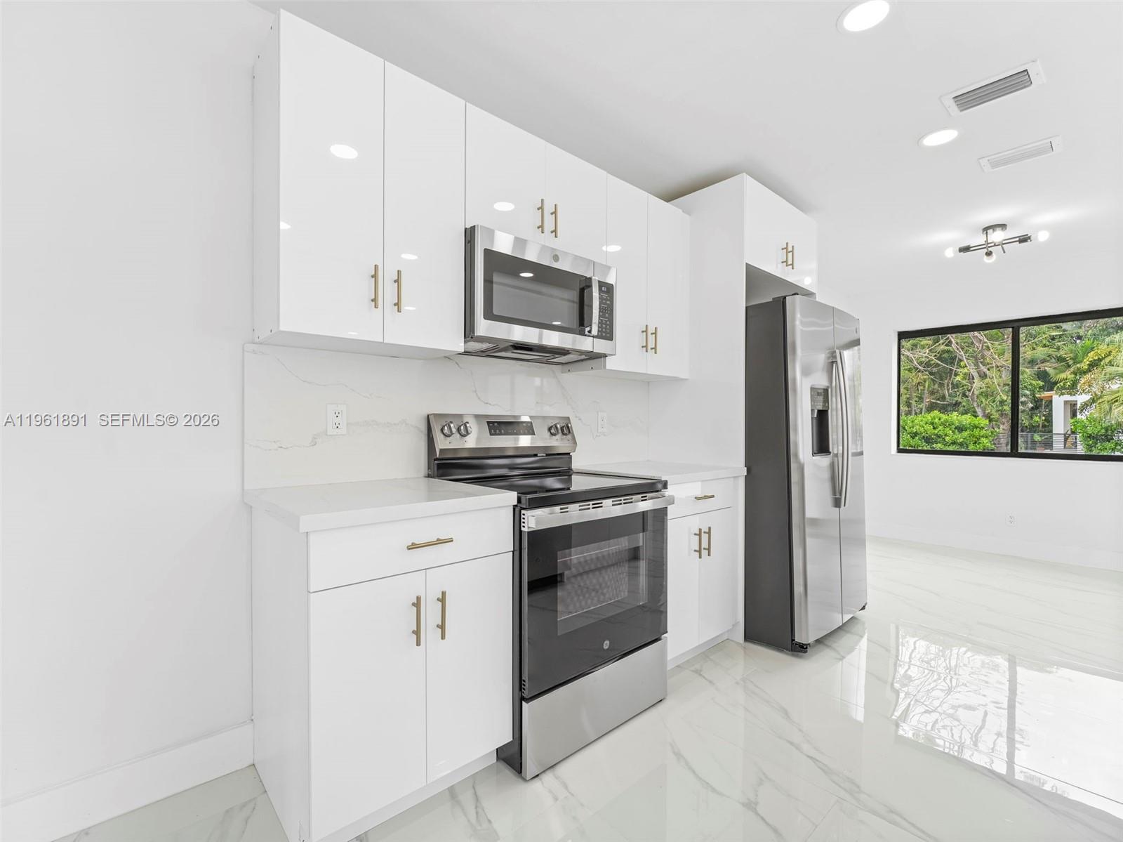 2500 Southwest 23rd Terrace Miami, FL 33145 - Photo 10 of 36 a kitchen with stainless steel appliances granite countertop a stove a sink and a refrigerator