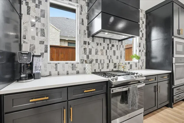 a kitchen with stainless steel appliances granite countertop a sink and a stove