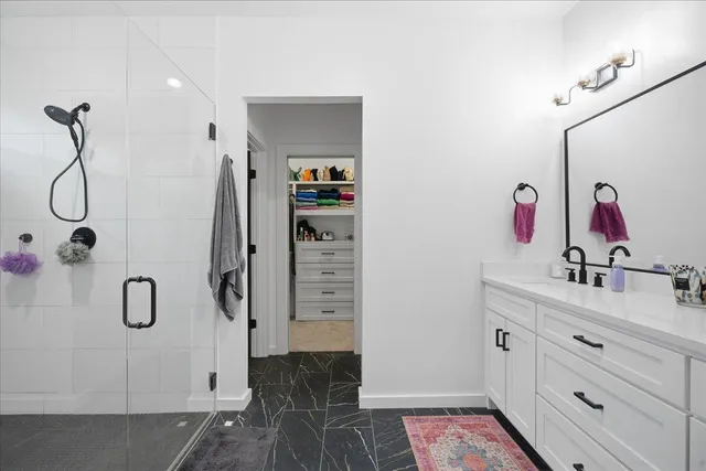 a bathroom with a double vanity sink mirror and shower