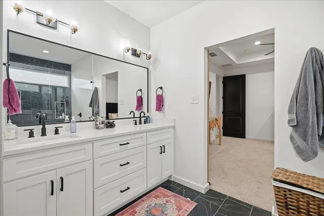 a en suite bathroom with double vanity and a mirror
