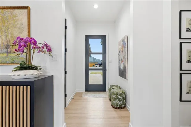 a view of a hallway and wooden floor and front door
