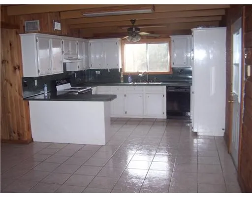 a kitchen with a sink window and cabinets