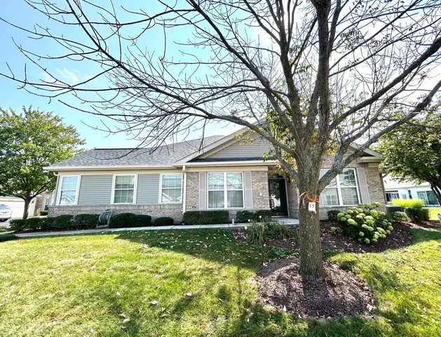 a front view of house with yard and trees around