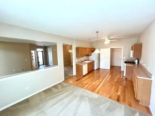 a large kitchen with a sink and wooden floor