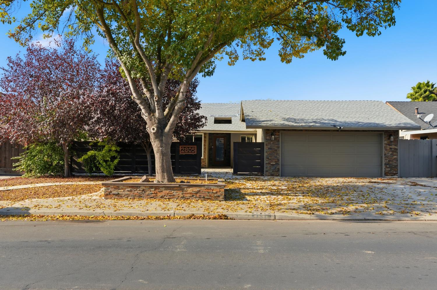 a view of a house with a tree in front of it
