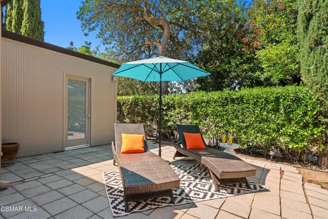 a view of backyard with outdoor seating and trees