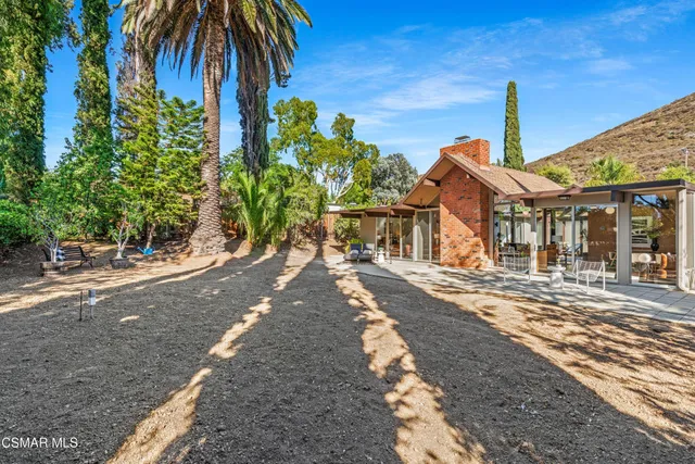 a view of a house with swimming pool and a chairs