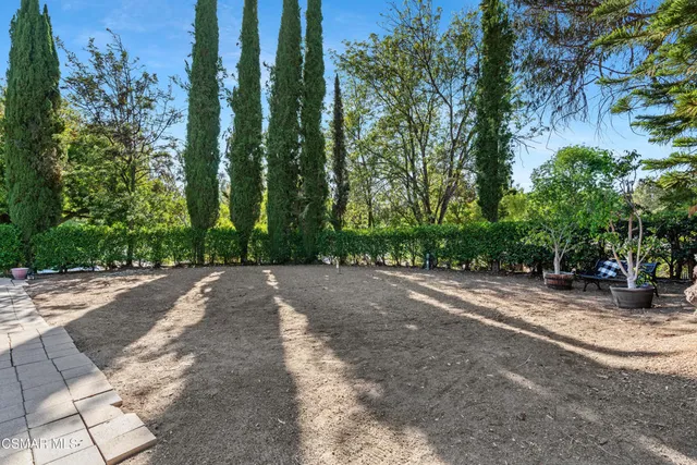 a view of a swimming pool with lawn chairs under an umbrella