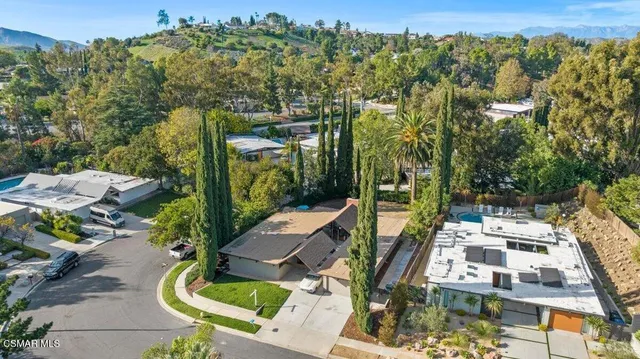 an aerial view of residential houses with outdoor space and trees