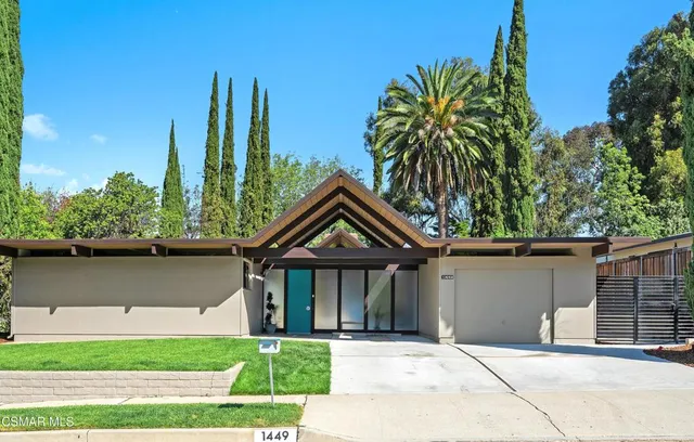 a front view of a house with a garden and plants
