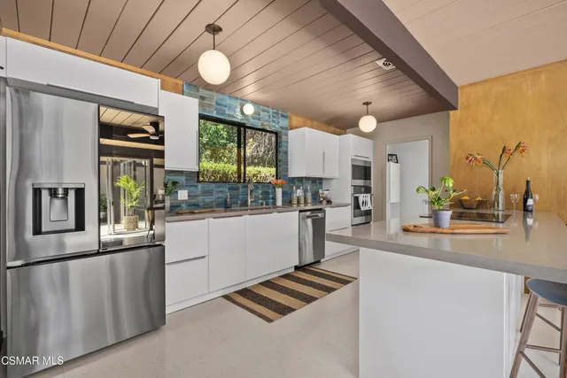 a kitchen with stainless steel appliances kitchen island granite countertop a stove and cabinets