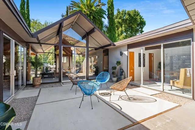 a view of a patio with table and chairs and potted plants