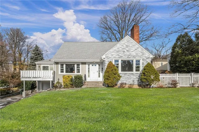 a front view of a house with a garden and yard
