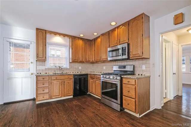 a kitchen with stainless steel appliances granite countertop a stove a sink and a microwave