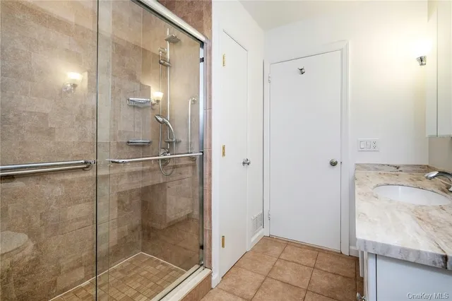 a bathroom with a granite countertop shower and a sink