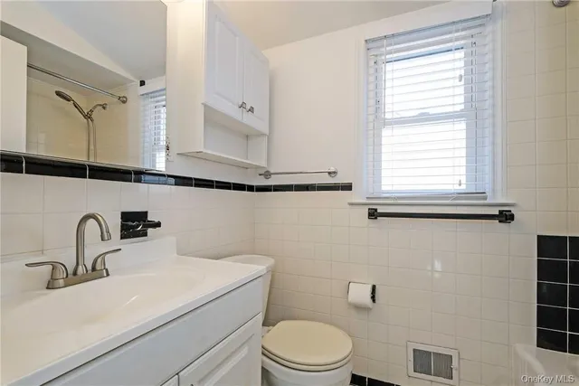 a bathroom with a sink a toilet and a mirror