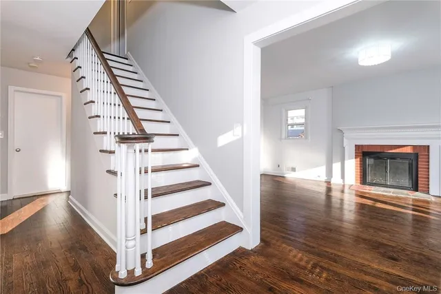 a view of a livingroom with wooden floor and staircase