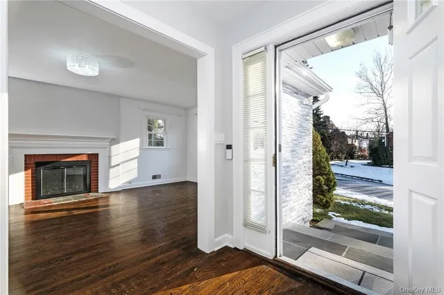 a view of a livingroom with wooden floor and a fireplace