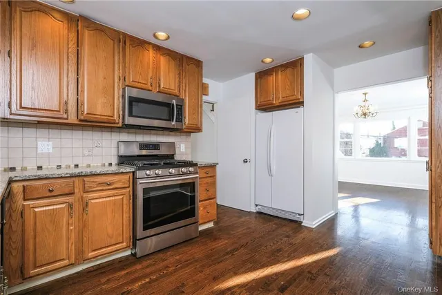 a kitchen with stainless steel appliances granite countertop a stove a sink and a microwave