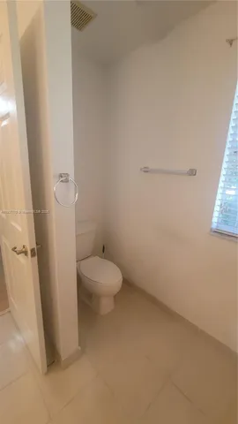 a bathroom with a granite countertop shower and a toilet
