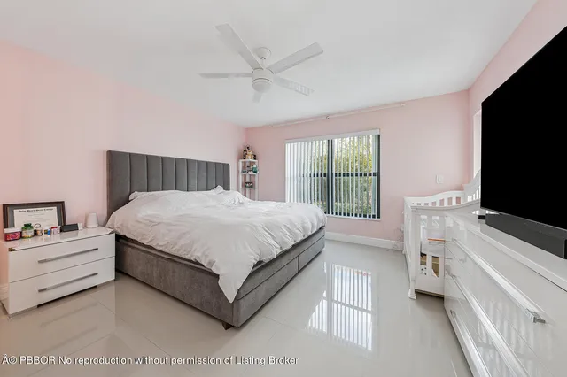 a bedroom with a bed and a flat tv screen on dresser