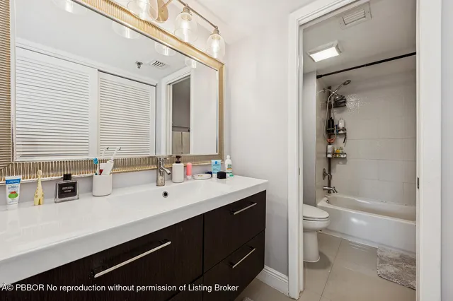 a bathroom with a double vanity sink toilet and shower