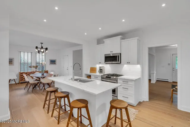 a kitchen with stainless steel appliances a table and chairs in it