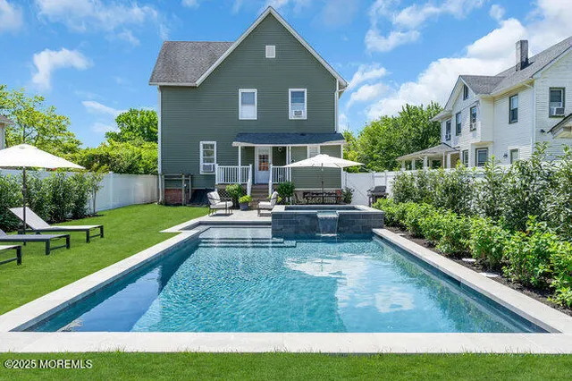 a view of house with garden and a bench