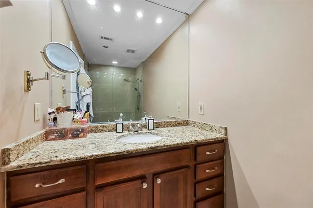 a bathroom with a granite countertop sink and a mirror