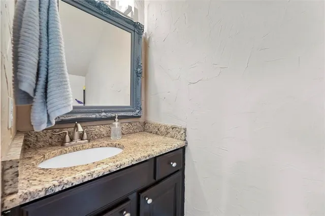 a bathroom with a granite countertop sink and a mirror