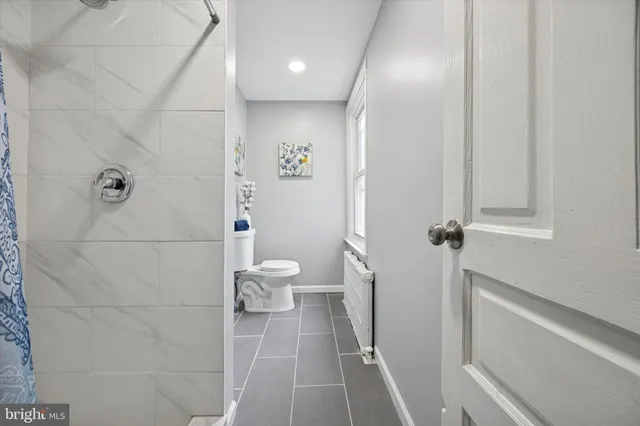 a bathroom with a toilet and a shower