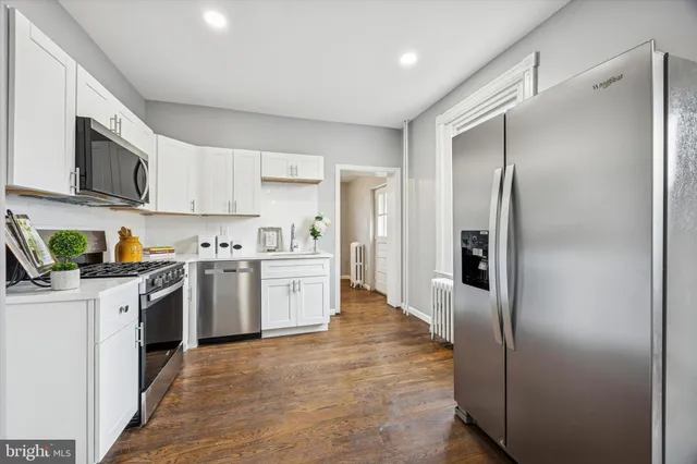 a kitchen with white cabinets and stainless steel appliances