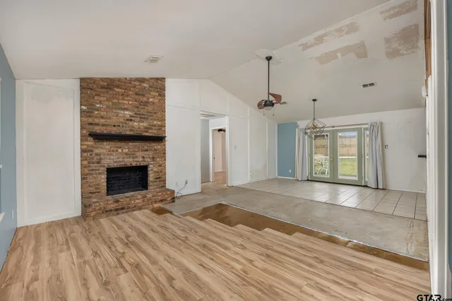 a view of an empty room with a fireplace and a window