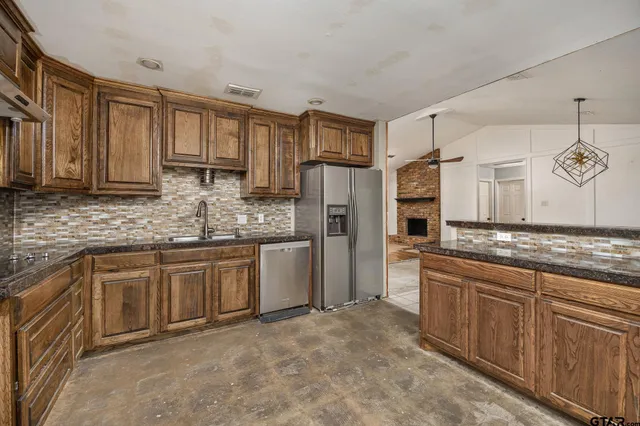 a kitchen with stainless steel appliances granite countertop a stove a sink and a refrigerator
