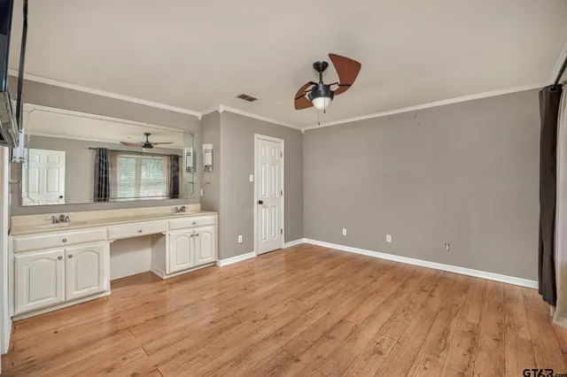 a large white kitchen with a sink stainless steel appliances and cabinets