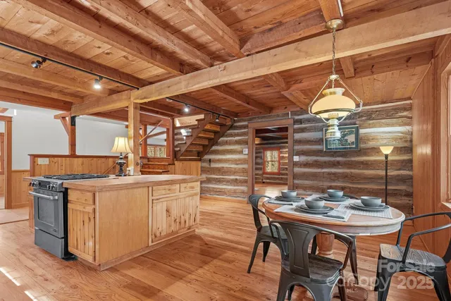 a kitchen with stainless steel appliances granite countertop a table chairs and wooden floor