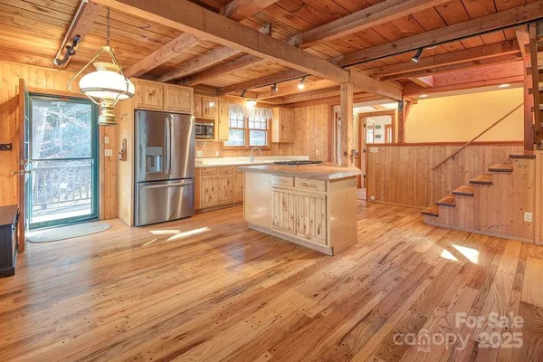a kitchen with stainless steel appliances granite countertop a refrigerator a stove and wooden floors