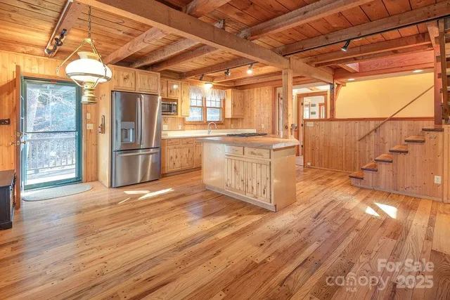 a kitchen with stainless steel appliances granite countertop a refrigerator a stove and wooden floors