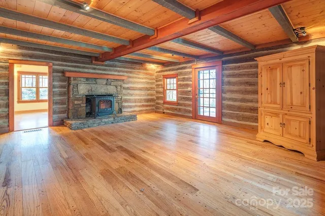 en empty room with wooden floor and fireplace
